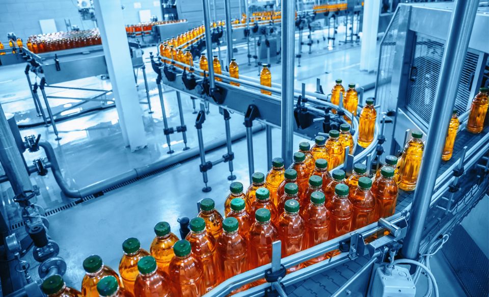 Beverage bottles moving along a conveyor in a bottling facility